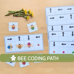 Peut inclure: Jeu éducatif avec des illustrations d'abeilles et des flèches directionnelles. Le jeu comprend des cartes avec des abeilles et des chemins de codage, ainsi que le texte "BEE CODING PATH". Des fleurs jaunes sont également présentes.