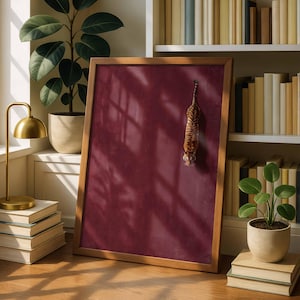 May include: A rectangular wooden frame containing a solid deep burgundy background with a small, realistic tiger figure positioned vertically in the center. The frame is displayed upright, showcasing a smooth, matte surface texture within the border.