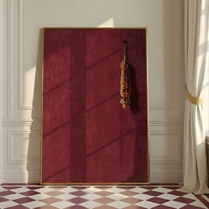 May include: A large rectangular wall art piece featuring a deep burgundy, textured background enclosed in a thin gold frame. A small, realistic tiger is depicted in a vertical, downward-facing position on the right side of the solid red surface.