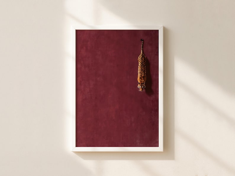 May include: A framed vertical wall art print featuring a deep burgundy textured background with a small, detailed illustration of a tiger positioned in the upper right quadrant, oriented vertically with its head pointing downward toward the bottom.
