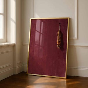 May include: A rectangular wall art piece in a thin gold frame featuring a deep burgundy background with a textured finish. A small, realistic tiger is depicted in a vertical, downward-facing position on the right side of the maroon surface.