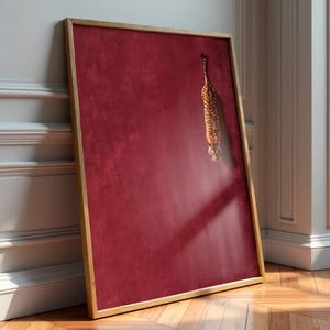 May include: A rectangular wall art piece in a light wood frame featuring a deep crimson red background with a textured finish. A small, detailed illustration of a tiger is positioned in the upper right quadrant, appearing to descend vertically.