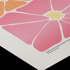 May include: A semi-glossy paper poster featuring a graphic floral pattern with large pink and orange petals and yellow centers. The text Classic Semi-Glossy Paper Poster 170 gsm (65 lb) is printed in the bottom corner of the white paper surface.