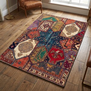May include: A colorful area rug with a patchwork design. The rug features a variety of geometric shapes in shades of blue, red, green, and beige. The rug has an intricate pattern and is placed on a hardwood floor.
