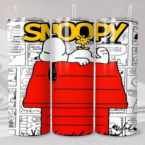 May include: Three white tumblers with a Snoopy design. The tumblers feature Snoopy in his red doghouse, with the word "Snoopy" in yellow. The background is a comic strip with speech bubbles and black and white illustrations.