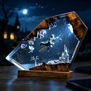 May include: A decorative resin night light featuring a wizard on a broomstick, a castle, and a bird against a starry night sky. The light is encased in a wooden frame and base, creating a 3D effect. The overall color scheme is blue, brown, and white.