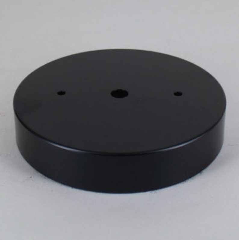 May include: Black round ceiling plate with three holes for electrical wiring.