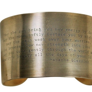 May include: A gold-toned metal bracelet with an engraved inscription that reads: "May the sun bring you new energy by day. May the moon softly restore you by night. May the rain wash away your worries. May the breeze blow new strength into your being. May you walk gently through the world and see it's beauty all the days of your life. ~apache blessing"