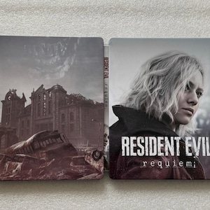 May include: A Resident Evil: Requiem steelbook case. The left side features a dilapidated building and a destroyed bus. The right side shows a woman with blonde hair. The title "RESIDENT EVIL requiem" is displayed.