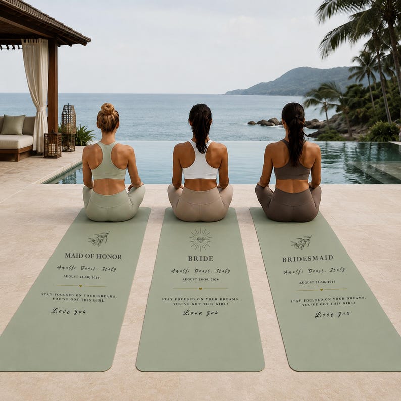 Pu&ograve; includere: Tre tappetini da yoga affiancati con le scritte "MAID OF HONOR", "BRIDE" e "BRIDESMAID". I tappetini sono verde chiaro con testo nero ed elementi decorativi. Vista sull'oceano sullo sfondo.