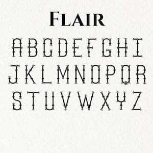 Puede incluir: Una tabla alfab&eacute;tica negra titulada FLAIR que muestra letras may&uacute;sculas de la A a la Z en una fuente decorativa con remates, l&iacute;neas dobles y adornos en los extremos, dispuestas en tres filas sobre un fondo blanco texturizado.