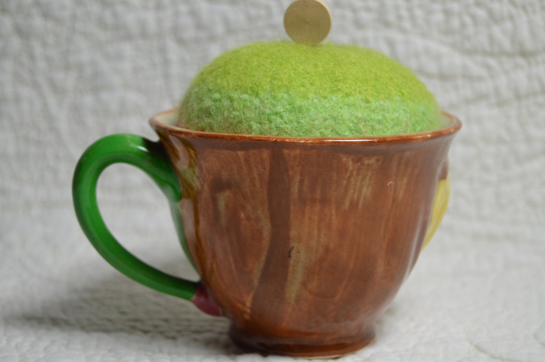 Hand-knitted felted wool pincushion in vintage Toby mug