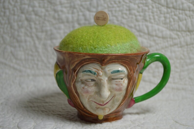 Hand-knitted felted wool pincushion in vintage Toby mug