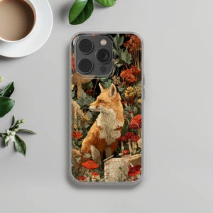 Op de afbeelding: Transparante telefoonhoes met een gedetailleerde illustratie van een vos in een bosrijke omgeving. Het kunstwerk bevat rode paddenstoelen, oranje bloemen en een vintage esthetiek. De vos is afgebeeld met oranje en witte vacht.