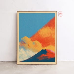Könnte beinhalten: Ein gerahmter Kunstdruck mit einer stilisierten Landschaft, die einen dunkelblauen Berggipfel vor einem leuchtenden Himmel in Orange, Gelb und Hellblau zeigt. Das Bild verwendet eine gepunktete Rastertextur und hat ein kleines Palmenlogo oben rechts.
