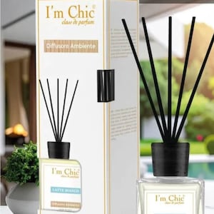 Puede incluir: Una botella de vidrio cuadrada de difusor "Latte Bianco" con cañas negras y una tapa negra, junto a una caja blanca con la misma marca. La caja y la botella tienen el texto "I'm Chic" y "Diffusore Ambiente". Hecho en Italia.