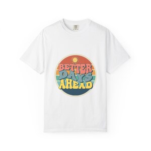 May include: White t-shirt with a retro design. The design features the text "Better Days Ahead" in colourful, rounded letters within a circular shape with a sun graphic. The shirt is made of a soft material.