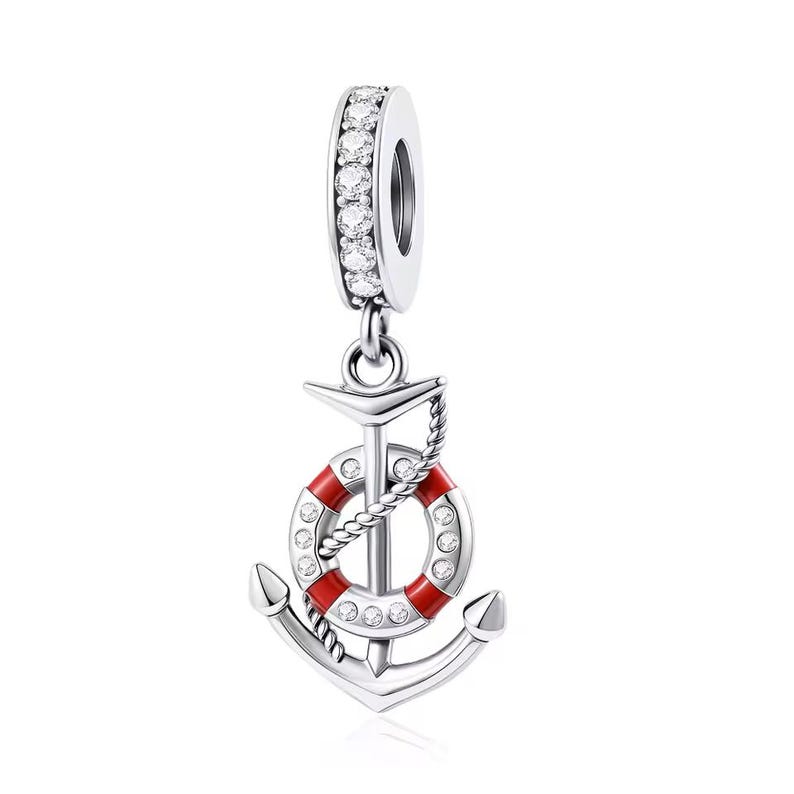 May include: A silver charm featuring a vertical anchor design with a red and white life preserver ring attached. The charm includes a bail encrusted with clear stones, and the life preserver ring is accented with small clear stones along its surface.