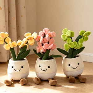 May include: Three plush flower pot toys with smiling faces, each holding a different color of flowers: yellow, pink, and green. The pots have small brown feet. A stuffed dinosaur is in the background. The Jellycat logo is in the top left corner.