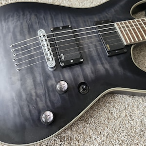 May include: A set of three ceramic mugs with a speckled, matte finish. The mugs are in cream, light grey, and dark grey. Each mug has a simple, minimalist design, ideal for coffee or tea.