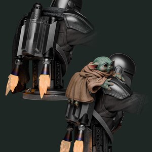 May include: A detailed statue of The Mandalorian with Grogu. The Mandalorian is in black armor with a jetpack, and Grogu is wrapped in a brown cloak. The jetpack has orange flame effects. The statue is on a dark gray base.