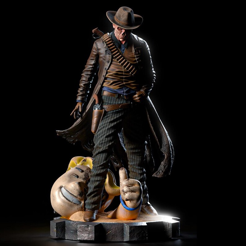 May include: A detailed figurine of a cowboy in a brown hat and long coat, standing over a smiling face and a hand giving a thumbs up. The cowboy has a gun holster, bullet belt, and striped pants. The base is a gear-like shape.