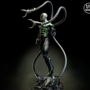 May include: A 1/6 scale statue of a superhero in a black and silver suit with green accents. The figure has four mechanical arms extending from its back. The statue is posed on a detailed base with debris.