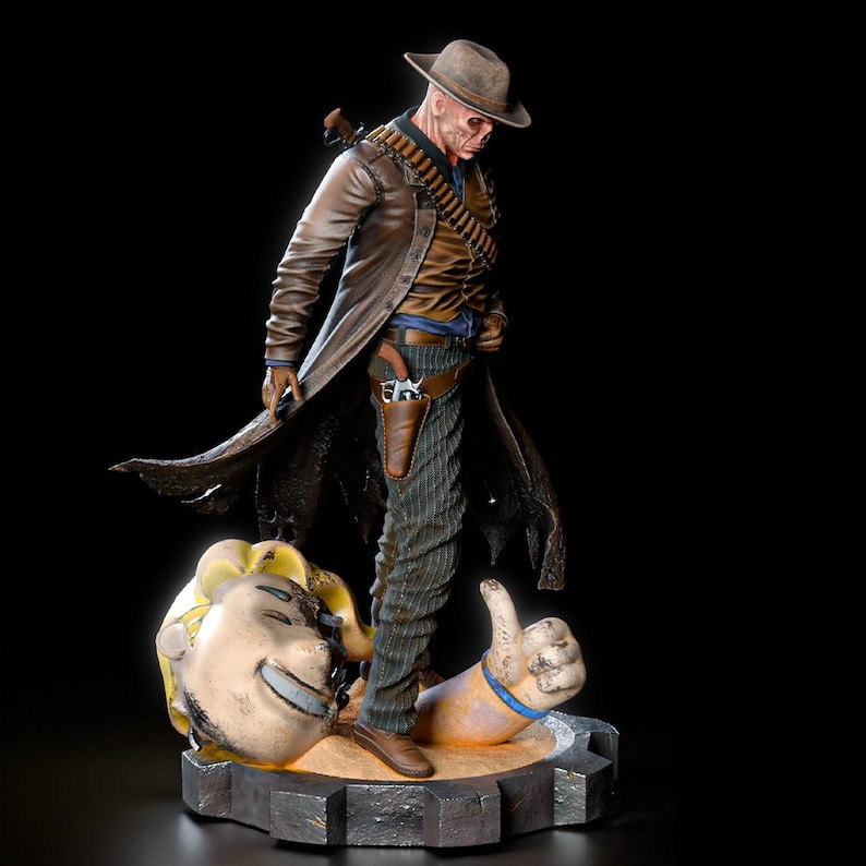 May include: A detailed figurine of a character in a brown duster coat, hat, and holster, standing over a smiling head and a thumbs-up hand. The figure has a weathered appearance, with a gun in the holster and a bandolier of bullets.