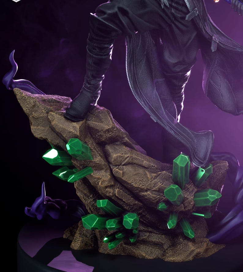 May include: A detailed figurine featuring a figure in black attire, standing on a rocky base adorned with vibrant green crystal formations. The base is a textured brown, set against a dark purple backdrop.