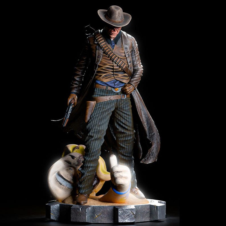 May include: A detailed figurine of a cowboy in a long coat, hat, and gun. The figure stands on a base with a dog and a hand giving a thumbs up. The cowboy wears a brown leather coat, vest, and hat, with pinstripe pants.