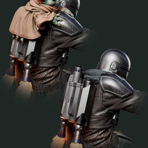 May include: A detailed figurine of The Mandalorian with Grogu. The Mandalorian is wearing a dark gray helmet and armor, with a jetpack on his back. Grogu, wrapped in a brown cloak, is perched on his shoulder. The image has a dark green background.