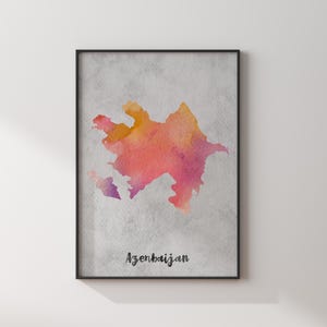 Peut inclure: Une affiche encadrée représentant une carte aquarelle de l'Azerbaïdjan dans des tons orange, rose et violet sur un fond gris clair texturé. Le mot Azerbaijan est imprimé en lettres cursives noires au bas de l'affiche.