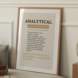 Può includere: Una stampa artistica incorniciata che presenta la parola ANALYTICAL in grassetto nero, seguita dalla pronuncia fonetica, una definizione e un paragrafo descrittivo su questo tratto, su uno sfondo beige chiaro in una cornice di legno.