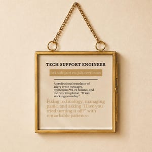 May include: A square brass-framed wall hanging featuring a printed definition of a Tech Support Engineer. The text describes the role as a professional translator of error messages and Wi-Fi failures, including the phrase, Have you tried turning it off?