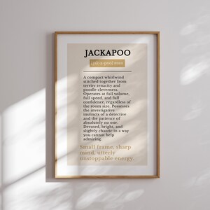 Pu&ograve; includere: Una stampa artistica incorniciata con una definizione in stile dizionario della parola JACKAPOO. Il testo &egrave; stampato in nero e oro su uno sfondo beige, descrivendo la razza canina con frasi come vortice compatto e mente acuta.