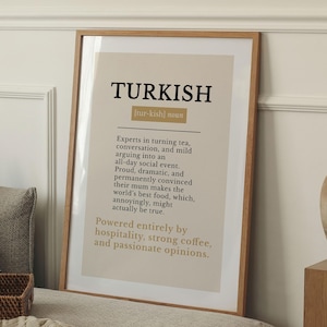 May include: A framed wall art print featuring a dictionary-style definition of the word TURKISH. The text is printed in black and gold on a beige background, describing cultural traits related to tea, food, hospitality, coffee, and opinions.
