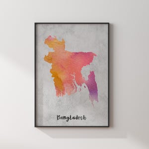 May include: A framed wall art print featuring a watercolour map of Bangladesh in shades of orange, pink, and purple against a textured light grey background. The word Bangladesh is printed in a black script font at the bottom of the map.