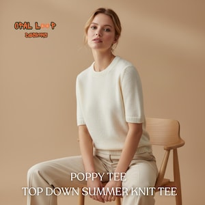 Puede incluir: Una mujer con un top de punto crema de manga corta y pantalones beige, sentada en una silla de madera. El top tiene cuello redondo y puños acanalados. El texto en la imagen dice "POPPY TEE" y "TOP DOWN SUMMER KNIT TEE". La marca "OPAL LOOP DESIGNS" también es visible.