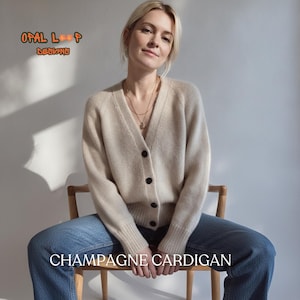 Puede incluir: Un cárdigan beige con cuello en V, mangas largas y cuatro botones oscuros en la parte delantera. El texto OPAL LOOP DESIGNS aparece en la esquina superior izquierda y el texto CHAMPAGNE CARDIGAN está centrado en la parte inferior.