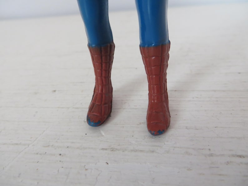 May include: A pair of red and blue boots with a webbed design. The boots are made of plastic and have a blue trim around the top.