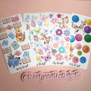 May include: Four rectangular sticker sheets featuring Winnie the Pooh characters, butterflies, flowers, and numbered circles with dollar amounts. Each sheet includes the text Beauty and the Budget. A pink sign displays @BeautyandtheBudgett.