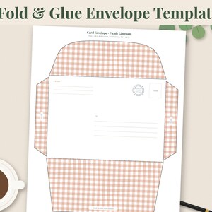 May include: A printable envelope template featuring a light pink and white gingham pattern. The flat layout includes designated areas for sender and recipient addresses, a stamp box, and fold lines. The text reads 4 Fold & Glue Envelope Templates.