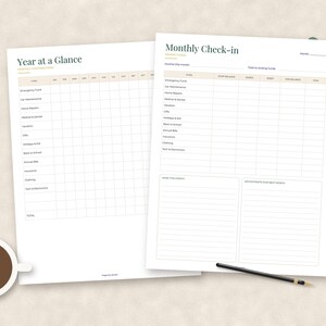 May include: Two white paper financial planning sheets featuring black text and grid lines. The left sheet is titled Year at a Glance, and the right sheet is titled Monthly Check-in. Both documents include rows for categories like Emergency Fund, Car Maintenance, and Home Repairs.