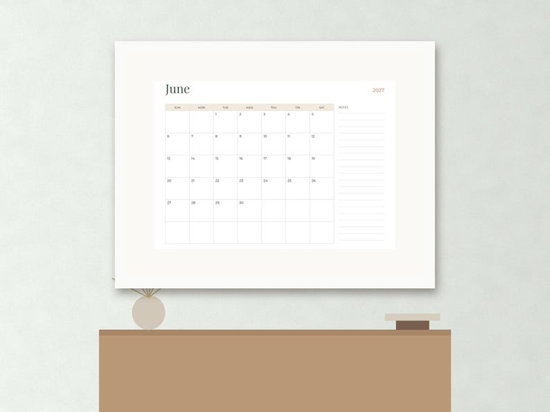 May include: A wall calendar for the month of June 2027 featuring a grid layout with days of the week, numbered dates, and a dedicated notes section on the right side. The design uses a clean white background with soft beige accents and black text.