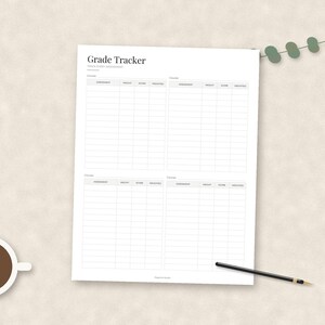 May include: A white paper sheet titled Grade Tracker with four distinct sections for recording course assessments, weights, scores, and weighted totals. The document features a clean grid layout with black text and lines, accompanied by a black pen.