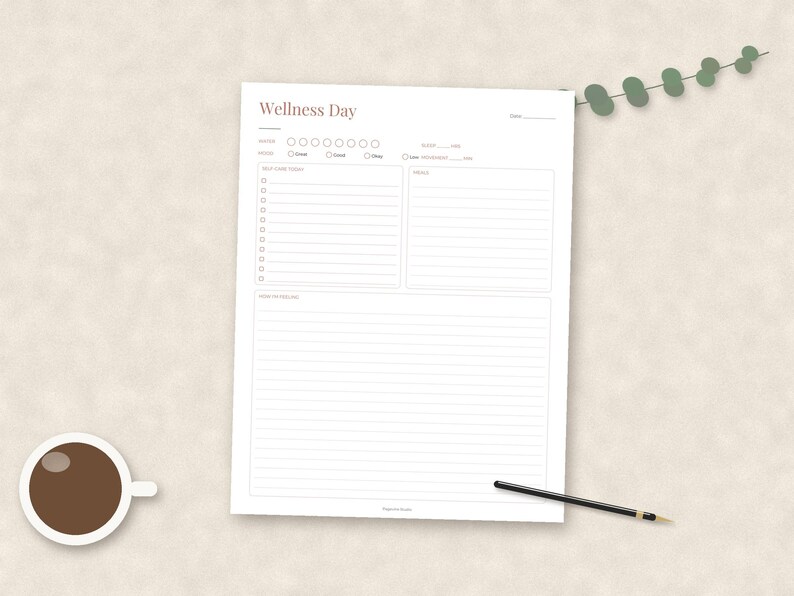 May include: A white Wellness Day planner sheet with sections for notes, mood, self-care, goals, and reflections. The page features a brown header, a cup of black coffee, and a black pen. A small green eucalyptus sprig is placed at the top right corner.
