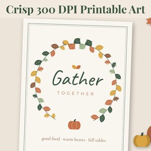 May include: A printable art poster featuring the text Gather TOGETHER in dark green and brown, surrounded by a circular wreath of colourful autumn leaves. Below the text is a small orange pumpkin and the words good food - warm hearts - full tables.