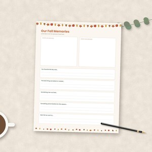 May include: A cream-colored paper sheet titled Our Fall Memories with a decorative border of autumn leaves and acorns. The page includes two blank rectangular boxes for photos and several lined sections for writing prompts about seasonal activities.