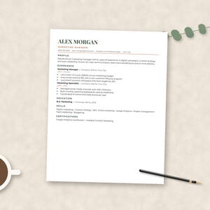 May include: A white resume template titled Alex Morgan Marketing Manager with sections for profile, experience, education, skills, and certifications. The document features black text on a white background, accompanied by a black pen and a cup of coffee.