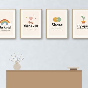 May include: Four rectangular wall art prints in light wood frames. The first features a rainbow and the text Be kind, IT'S COOL TO BE KIND. The second shows a heart and Say thank you, KIND WORDS MATTER. The third has overlapping circles and Share, IT'S MORE FUN TOGETHER. The fourth displays a potted plant and Try again, MISTAKES HELP US GROW.